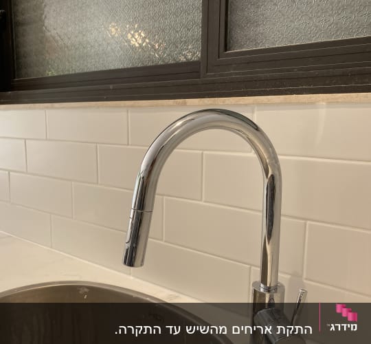 ברז כרום מעל כיור נירוסטה עם חיפוי קיר קרמיקה לבן